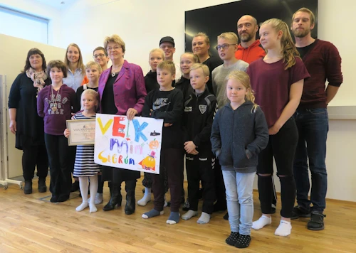 Skipst á skjölum. Sigrún Magnúsdóttir, umhverfis- og auðlindaráðherra ásamt umhverfisnefnd skólans sem skipuð er nemendum og starfsfólki. Sú yngsta í nefndinni tók á móti viðurkenningarskjali ráðherra sem í staðinn fékk glæsilegt veggspjald.