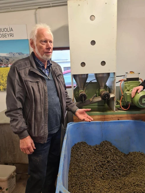 Ólafur Eggertsson, bóndi á Þorvaldseyri, við repjupressu á bænum.