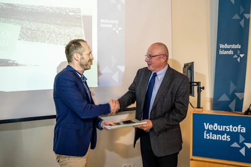 Árni Snorrason forstjóri Veðurstofu Íslands afhendir Guðmundi Inga Guðbrandssyni. umhverfis- og auðlindaráðherra, skýrsluna. 