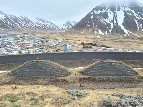 Brattar varnarkeilur ofan við háan, brattan þvergarð, ofan byggðar í Bolungarvík. Ljósmynd: KMH, 23. maí 2024.