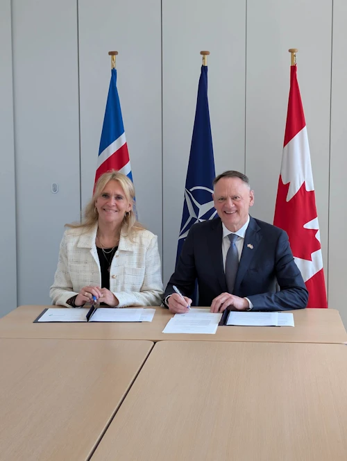 Þorgerður Katrín Gunnarsdóttir utanríkisráðherra og David McGuinty, varnarmálaráðherra Kanada, undirrita uppfært samkomulag um tvíhliða samstarf ríkjanna á sviði varnarmála.