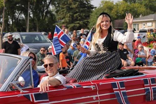 Áslaug Arna Sigurbjörnsdóttir, háskóla-, iðnaðar- og nýsköpunarráðherra, við hátíðarhöld tengd Íslendingadeginum í Gimli. Bílinn keyrir Stefan Stefanson, Vestur-Íslendingur búsettur í bænum.