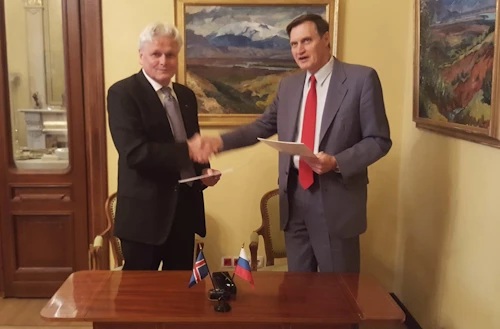 Stefán Lárus Stefánsson og Sergei Seskutov Anatolyevich takast í hendur eftir undirritunina.