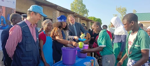 Yfirmaður WFP í Malaví, menntamálaráðherra Malaví, og Davíð Bjarnason, forstöðumaður sendiráðs Íslands í Lilongwe, reiða fram skólamáltíðir