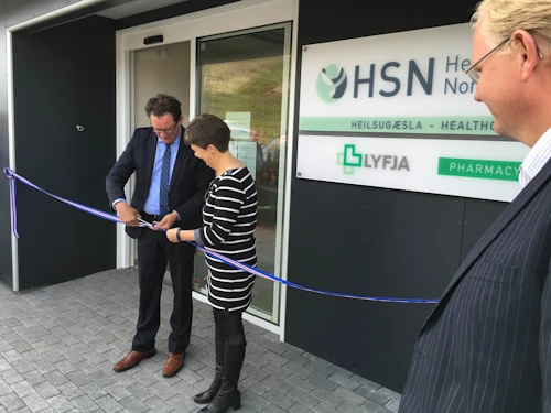 Kristján Þór Júlíusson heilbrigðisráðherra og Dagbjört Bjarnadóttir hjúkrunarfræðingur HSN klippa á borðann fyrir utan nýju Heilsugæslustöðina í Reykjahlíð.